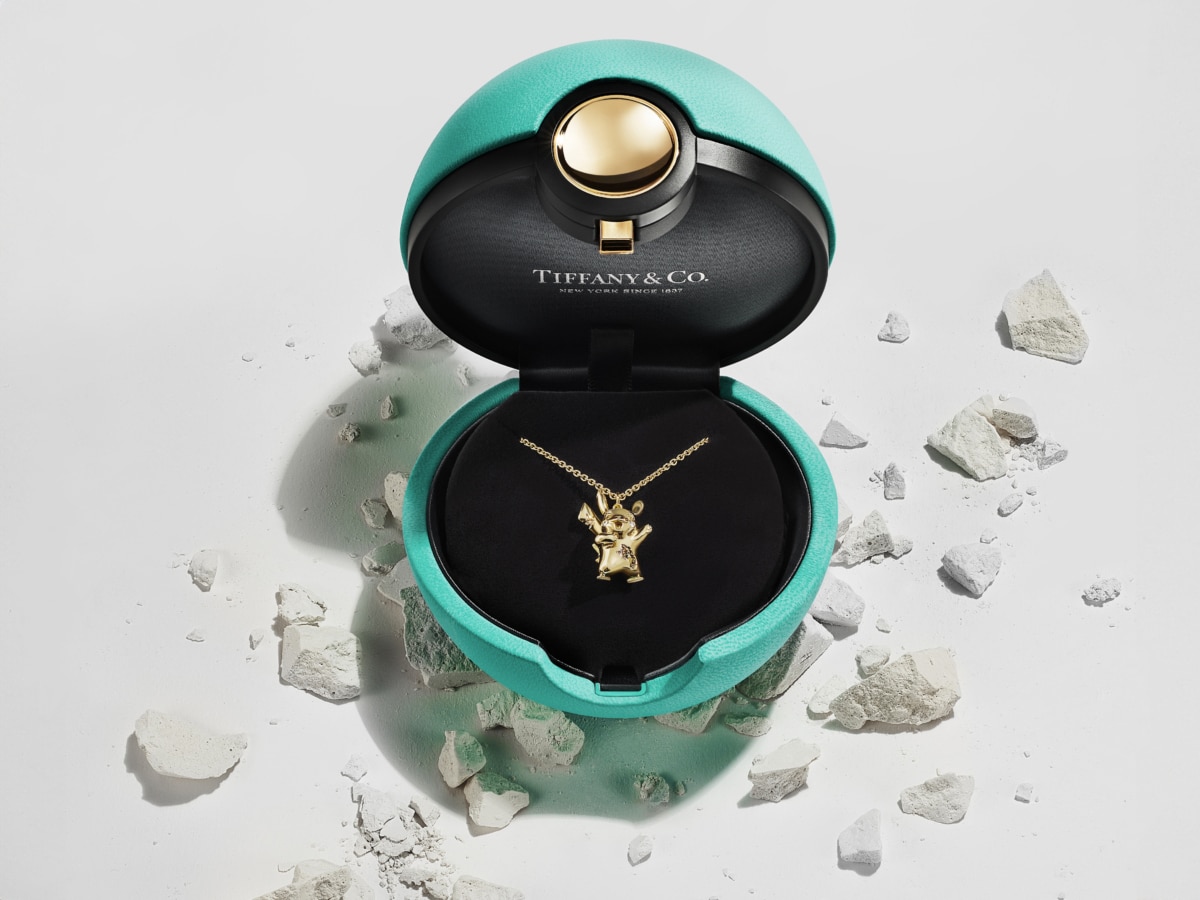 High angle shot of Tiffany & Co Daniel Arsham Poke Ball packaging showing gold Pikachu necklace