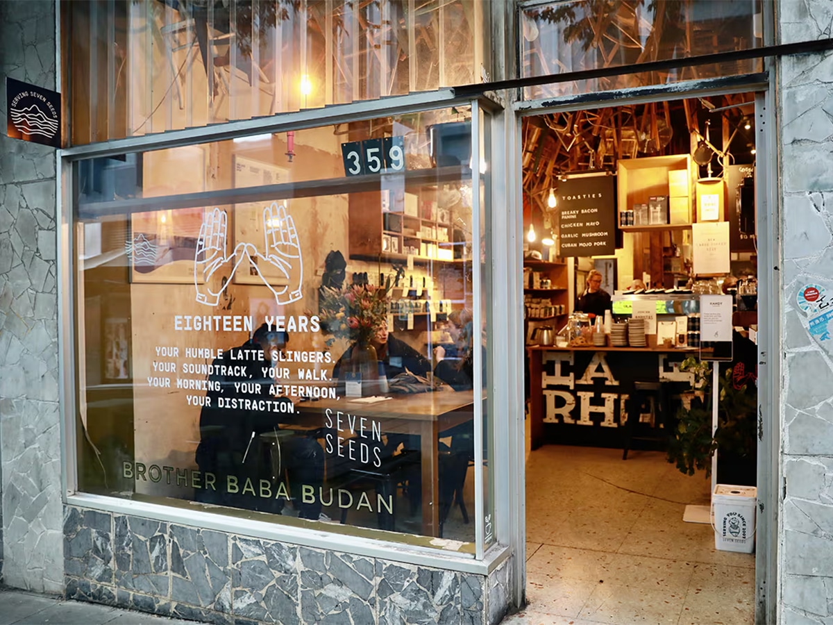 Exterior of Brother Baba Budan cafe with wide glass windows showing customers dining inside