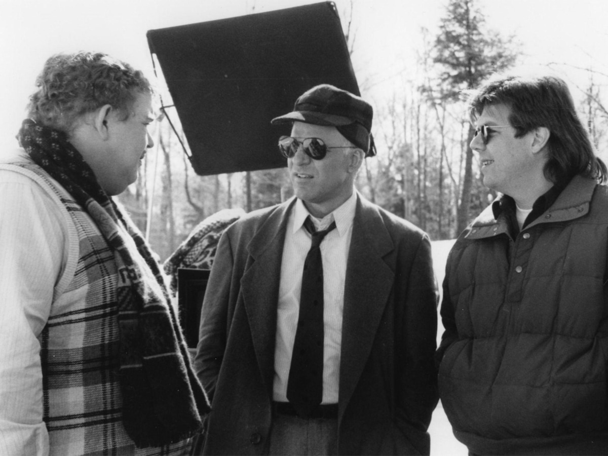 Greyscale photo of Steve Martin, John Hughes, and John Candy