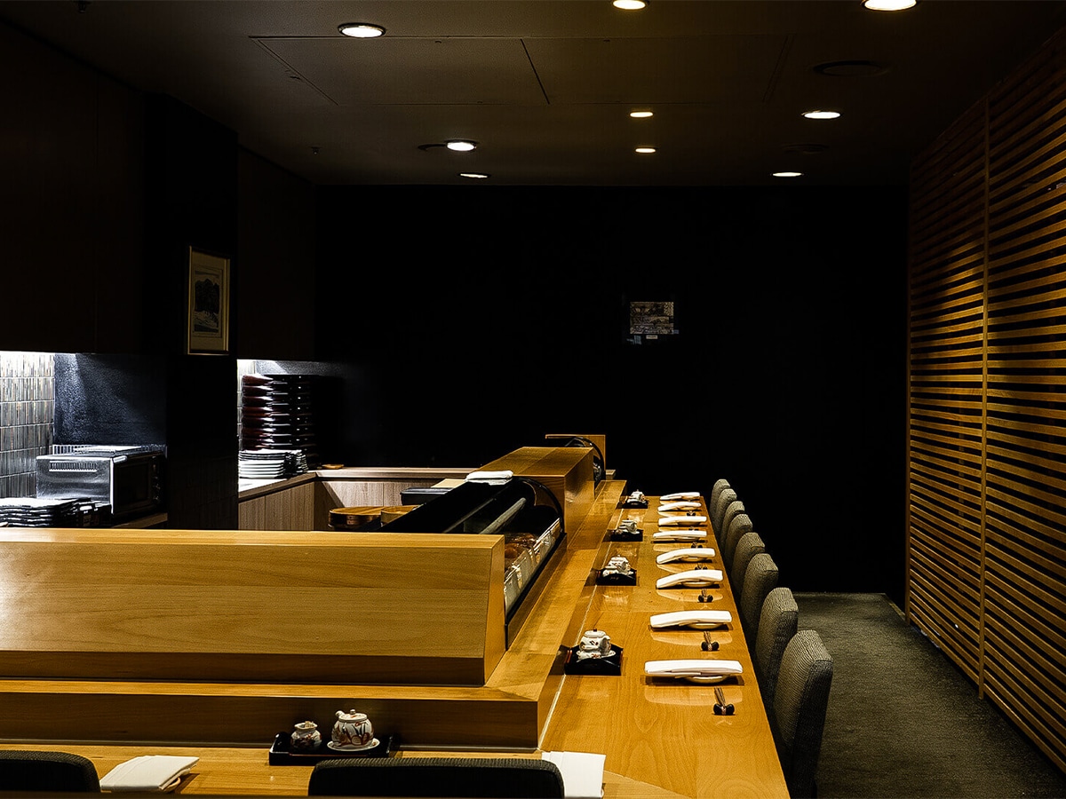 Interior of Kenzan Japanese Restaurant showing sushi bar and dark colour scheme