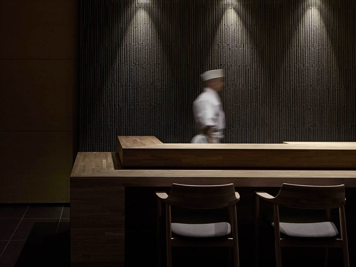 Interior of Minamishima Japanese restaurant showing chef behind sushi bar