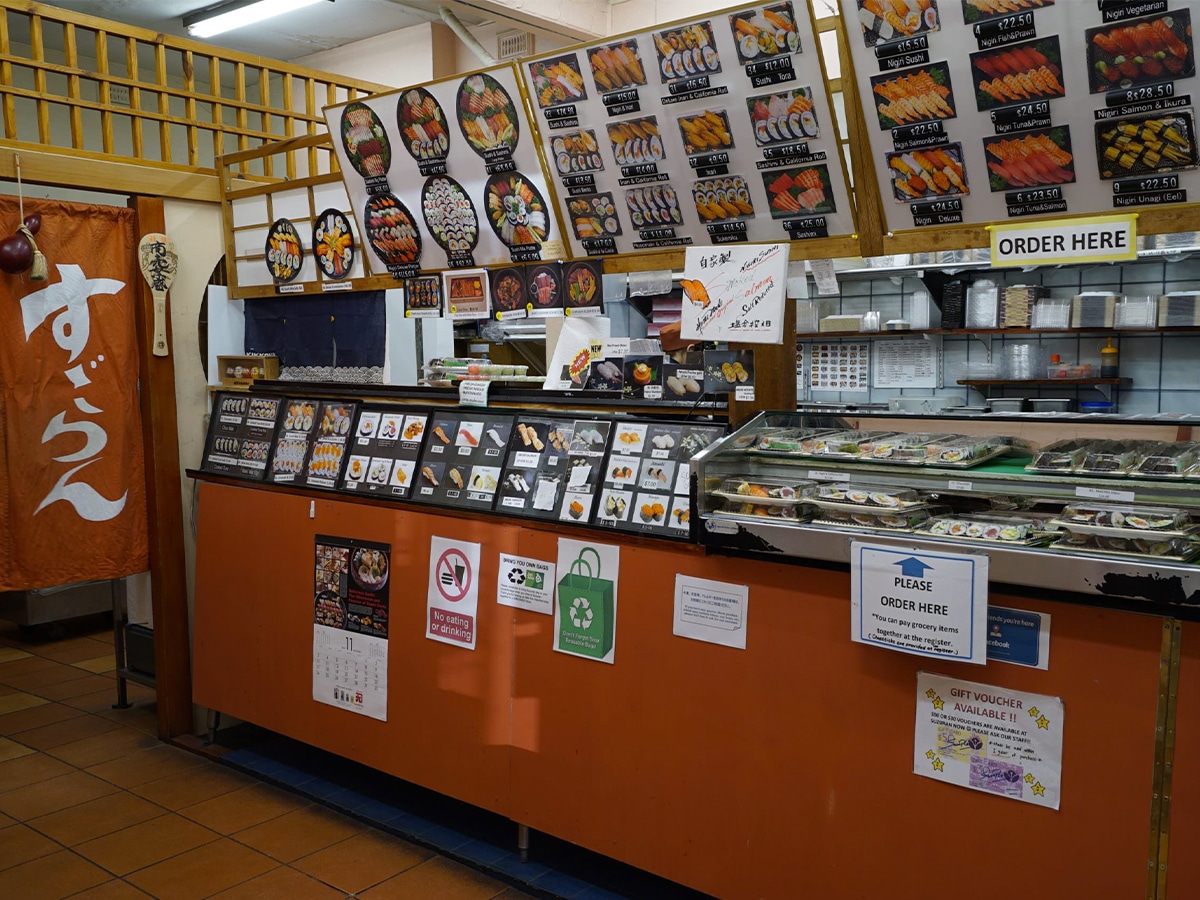 Interior of Suzuran Japanese restaurant showing counter area and menu