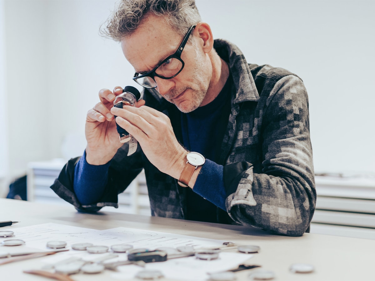 Jakob Wagner using a loupe to look at a Nordgreen watch