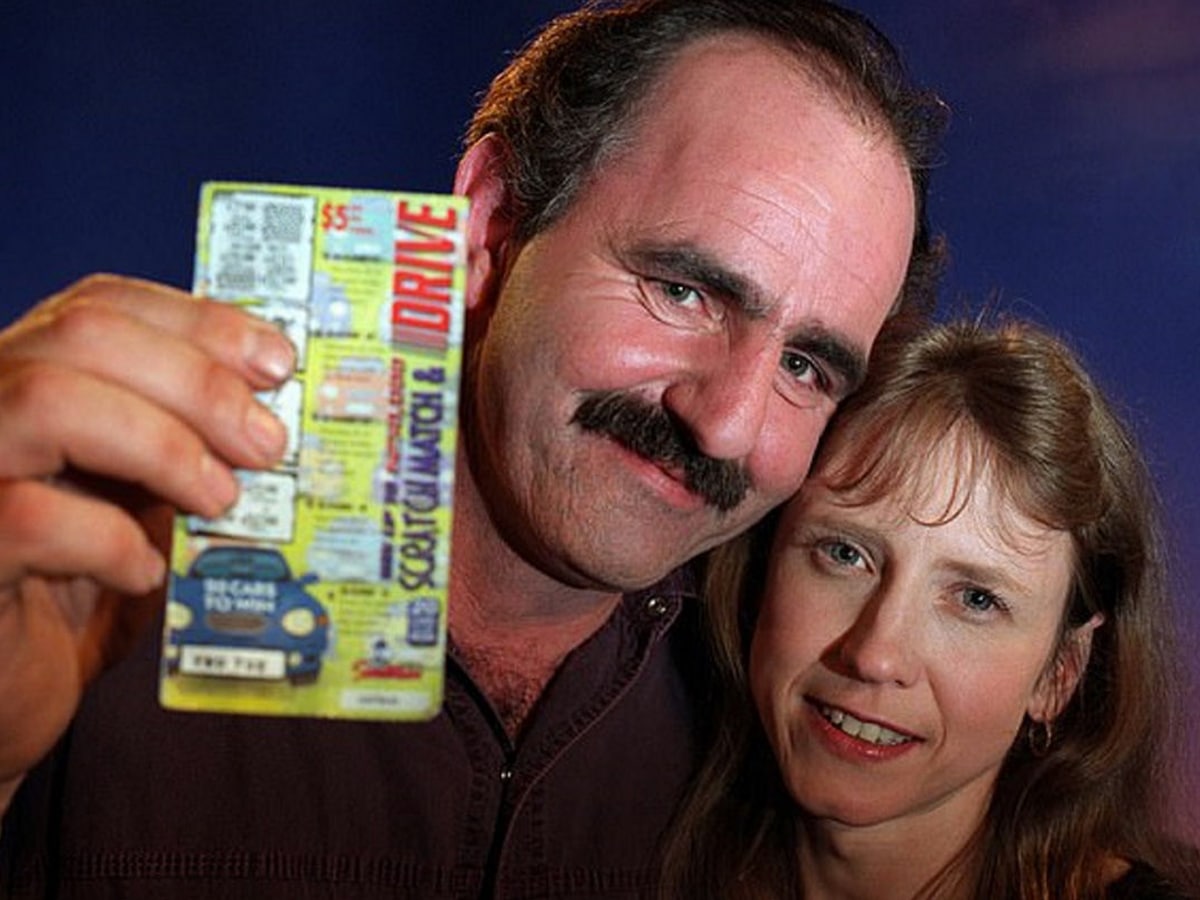 Bill Morgan holding a scratchie with a woman beside him