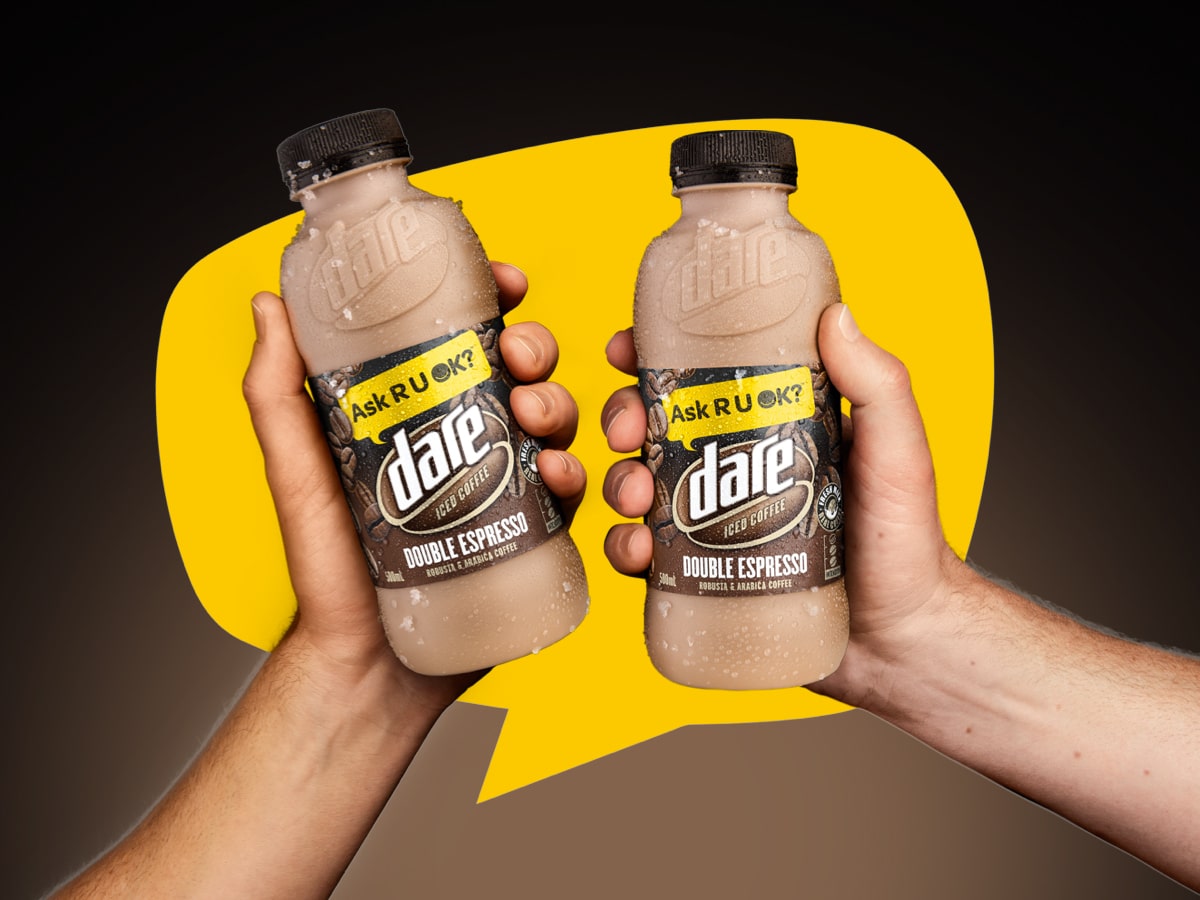 Edited image of two hands each holding a Dare Iced Coffee bottle