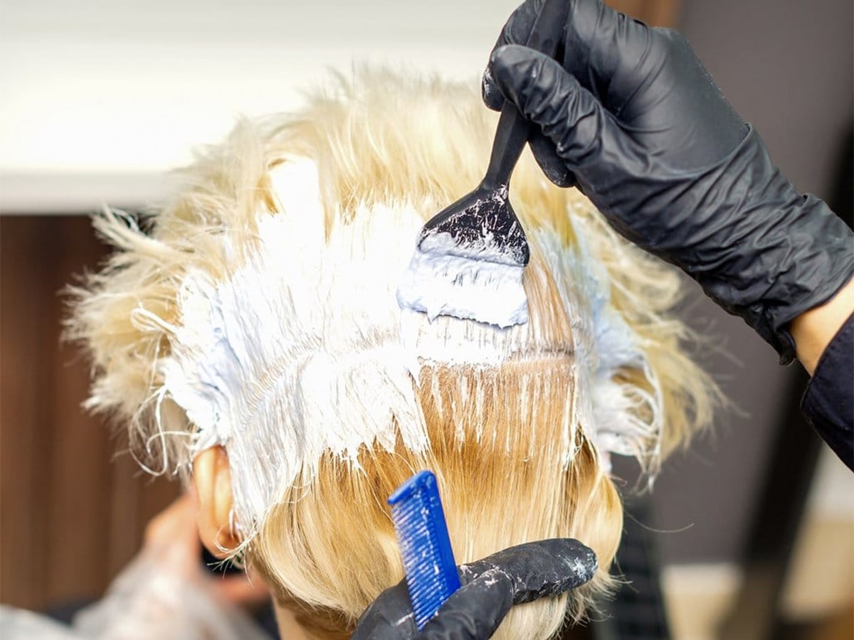 Hairdresser bleaching customer's hair