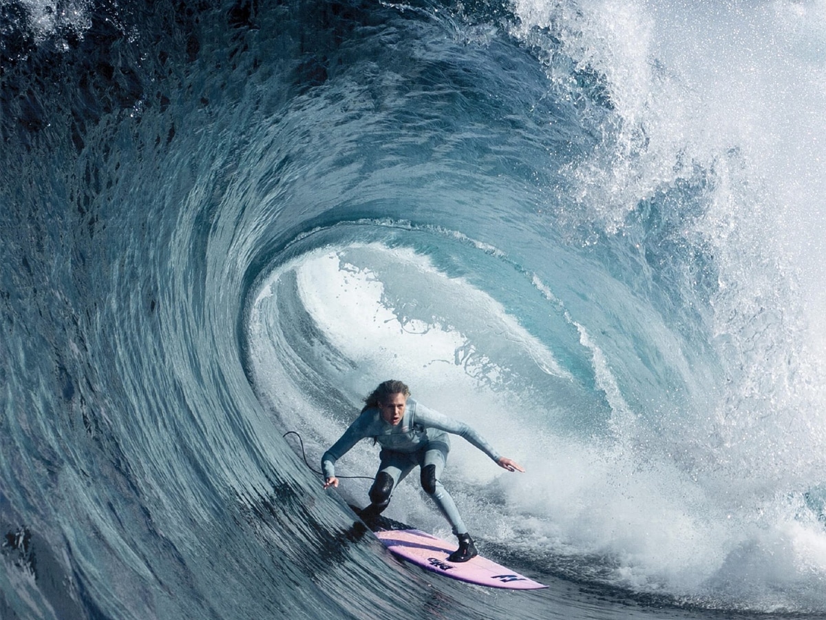 Woman surfing big wave