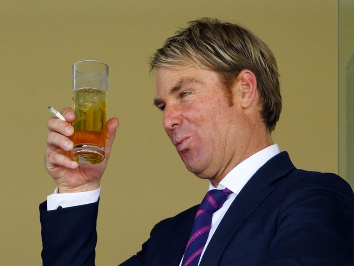 Shane Warne holding cigarette and a drink in one hand