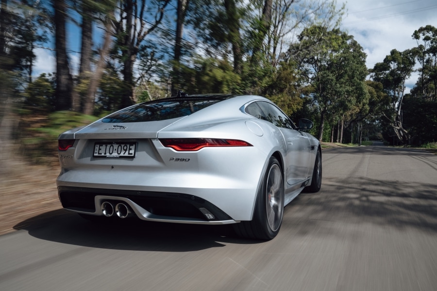 Angular rear view of the silver 2021 Jaguar F-type, driving on the road
