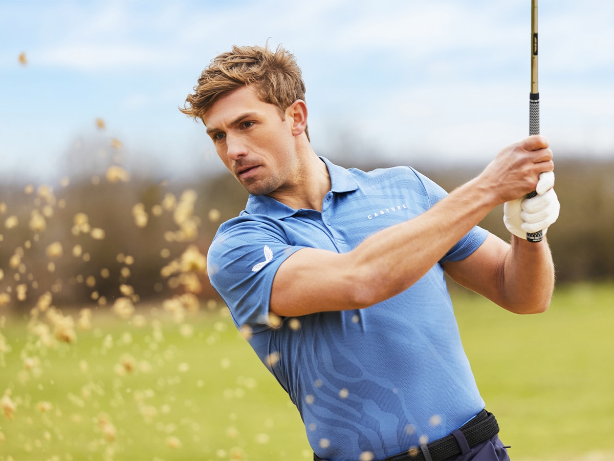 A golfer in a light blue shirt and white golf glove