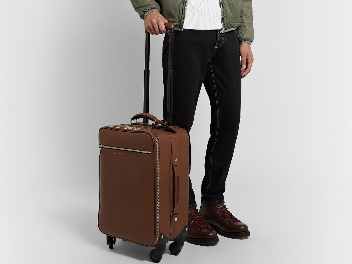 Male model holding brown Brunello Cucinelli luggage