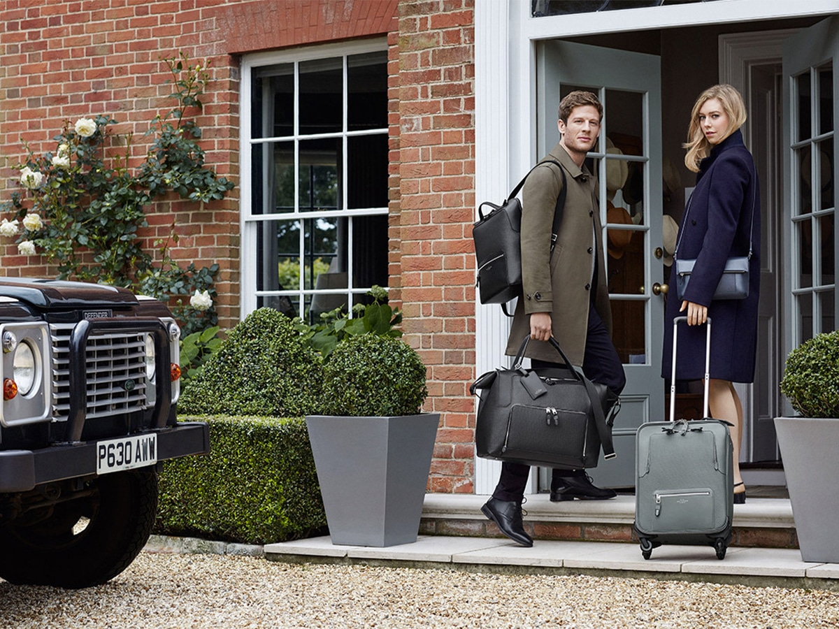 Male and female models carrying Smythson luggage