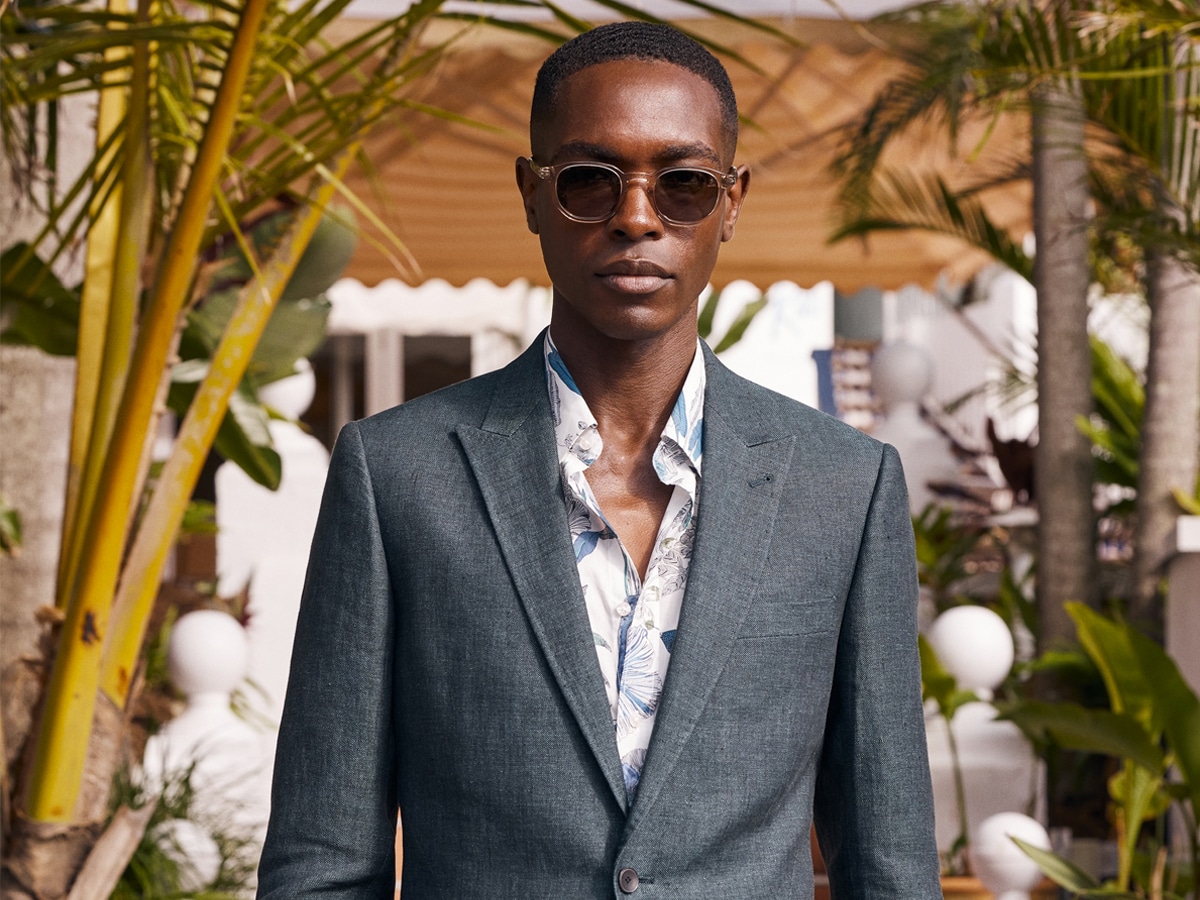 Male model wearing a printed shirt and a charcoal grey suit