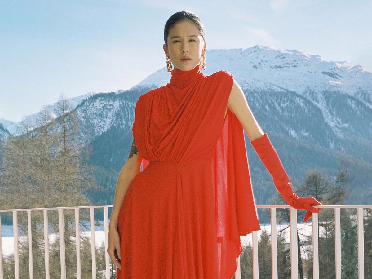 Female model wearing a red dress and a single elbow length red glove