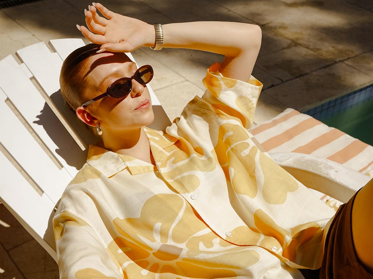 Female model wearing sunglasses and oversized yellow printed shirt