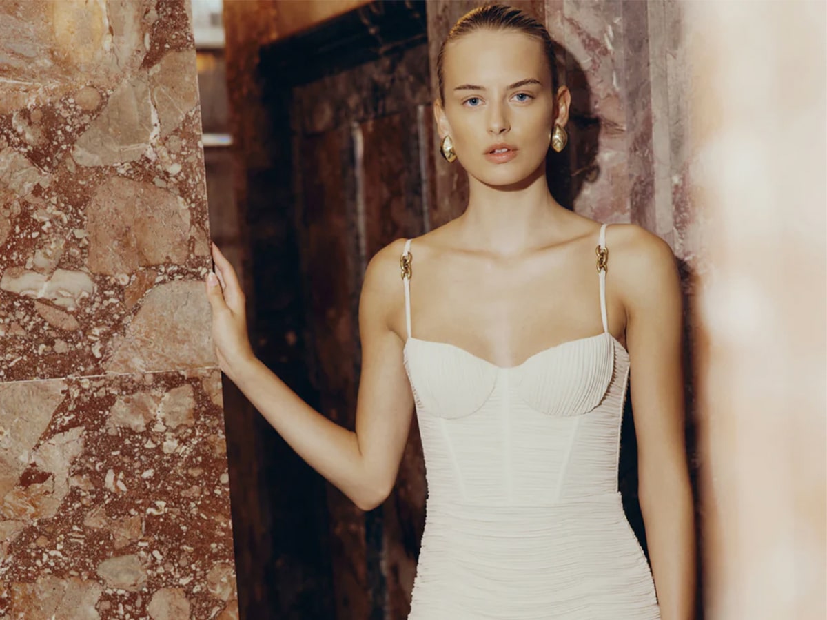 Female model wearing a white bodycon dress