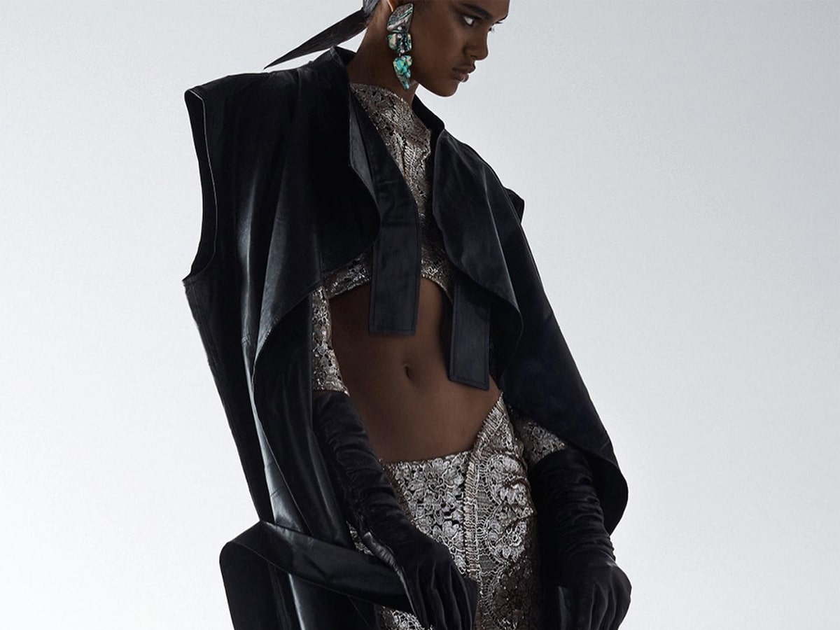 Female model wearing black structured blazer and silver outfit