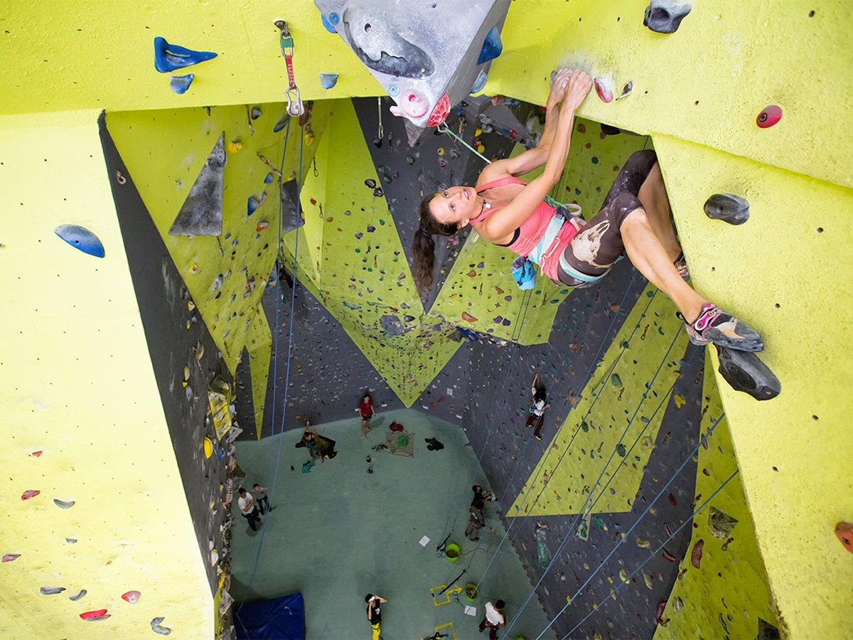 Woman at the very top of indoor climbing gym