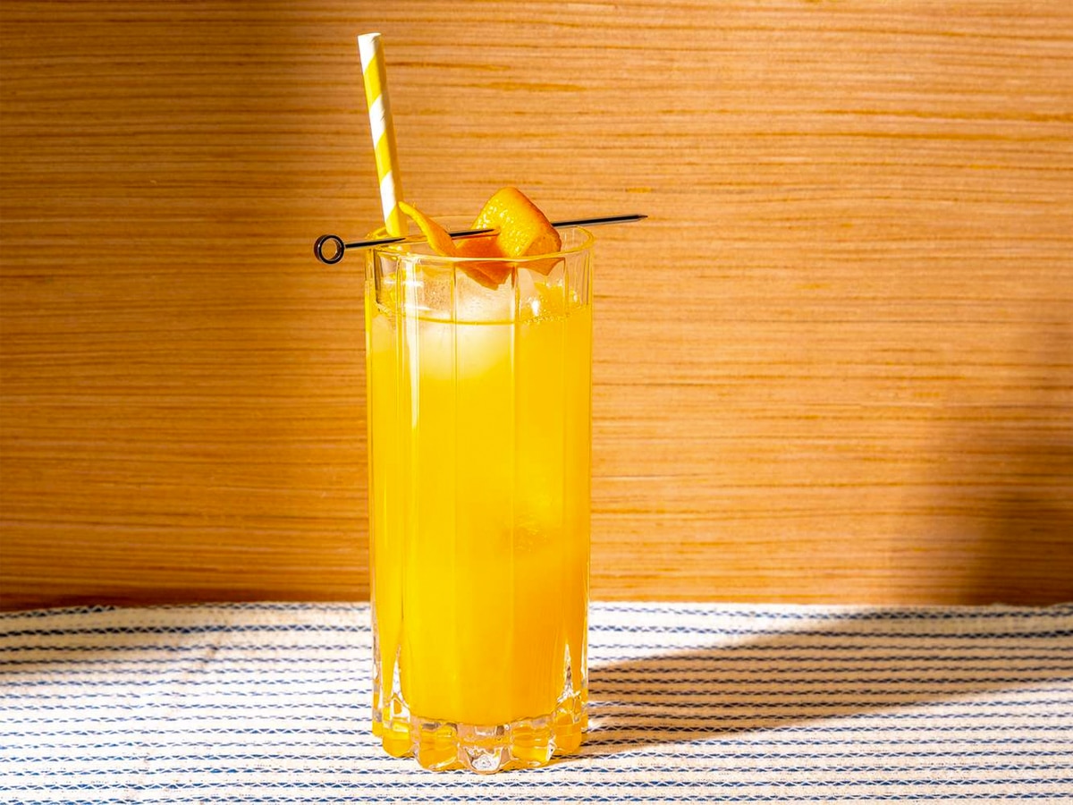 A glass of screwdriver cocktail on the rocks with orange slice garnish