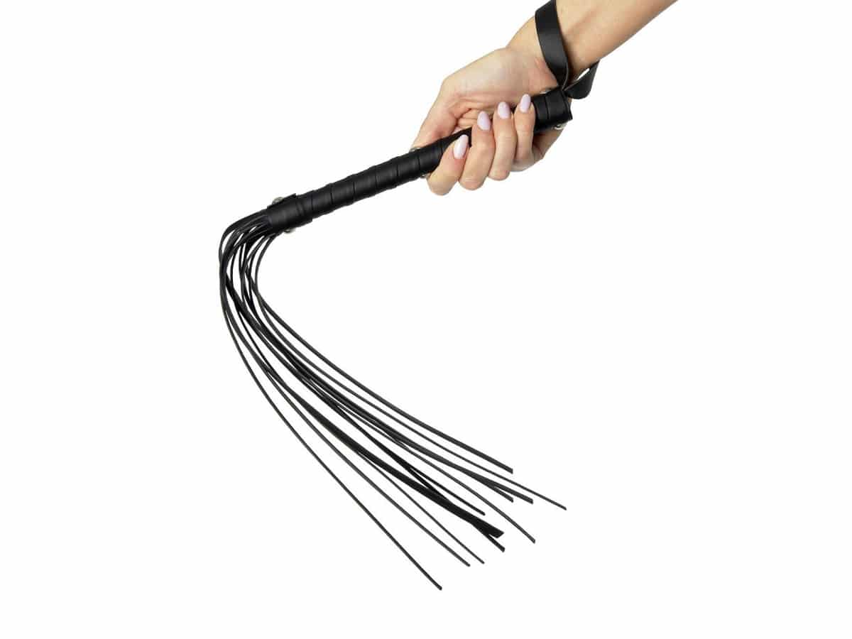 Hand holding a leather flogger