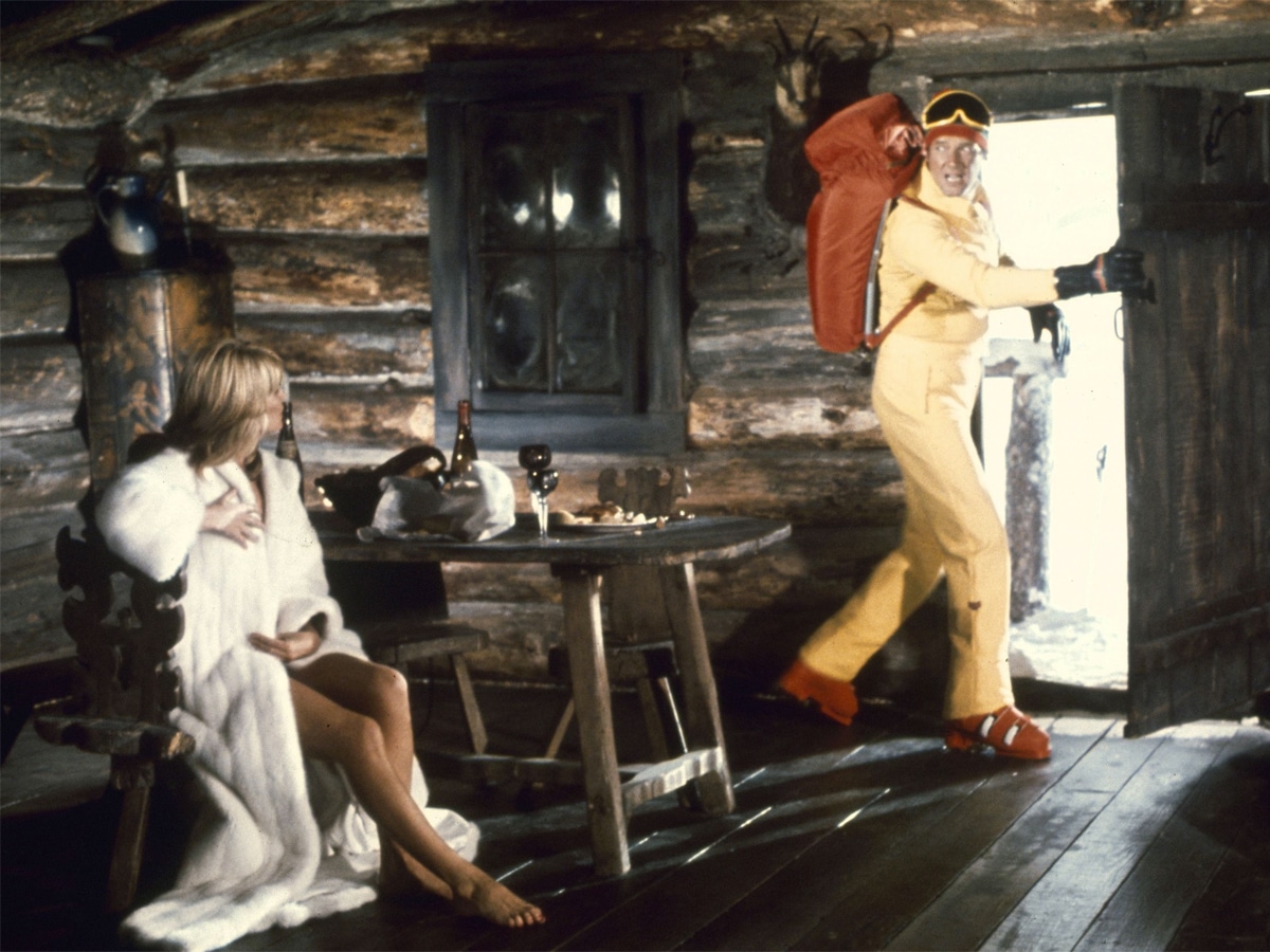 Sue Vanner and James Bond actor inside a log cabin