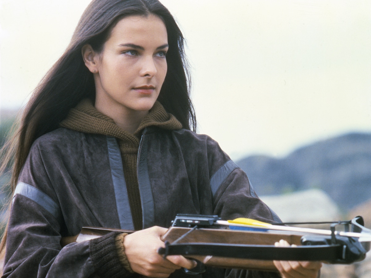 Carole Bouquet holding a crossbow