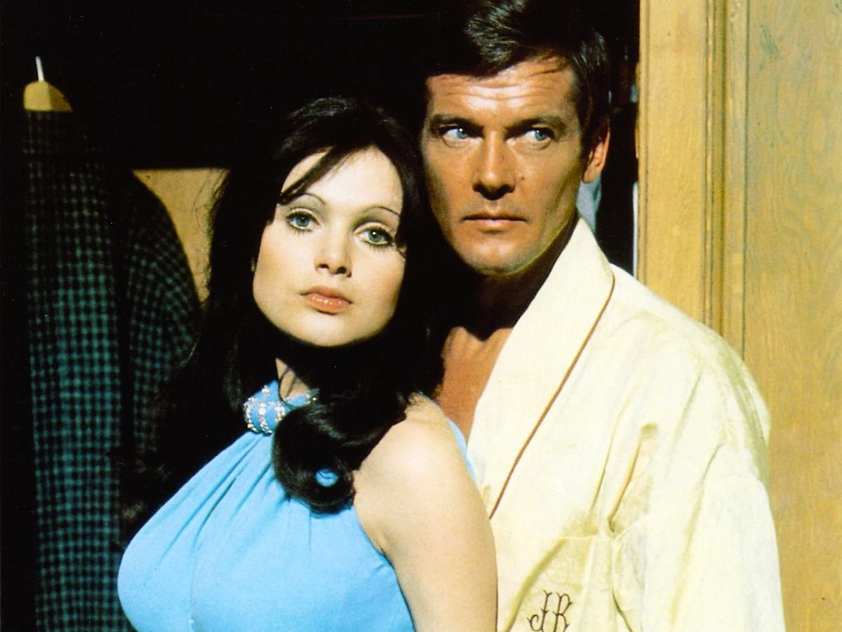 Madeline Smith in a blue dress beside a man