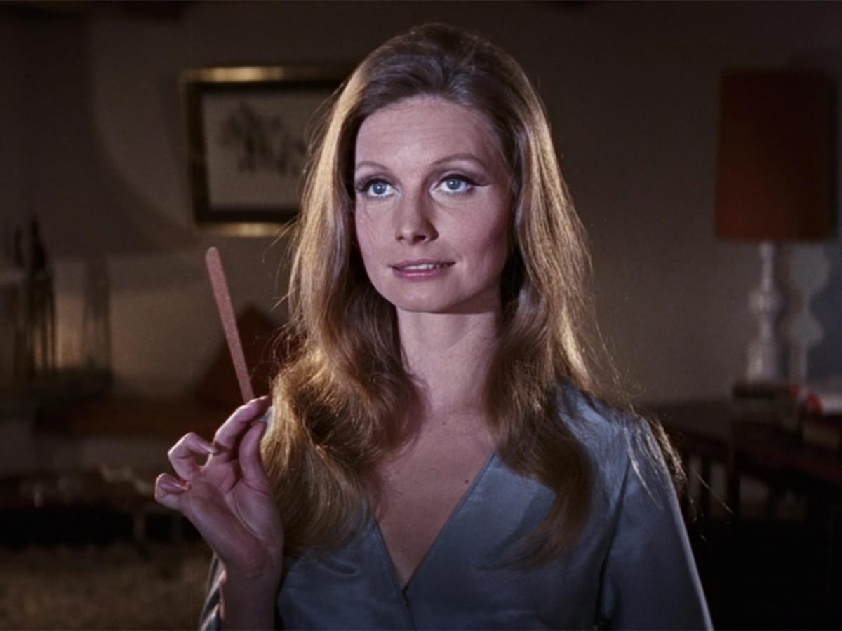 Catherine Schell holding a stick