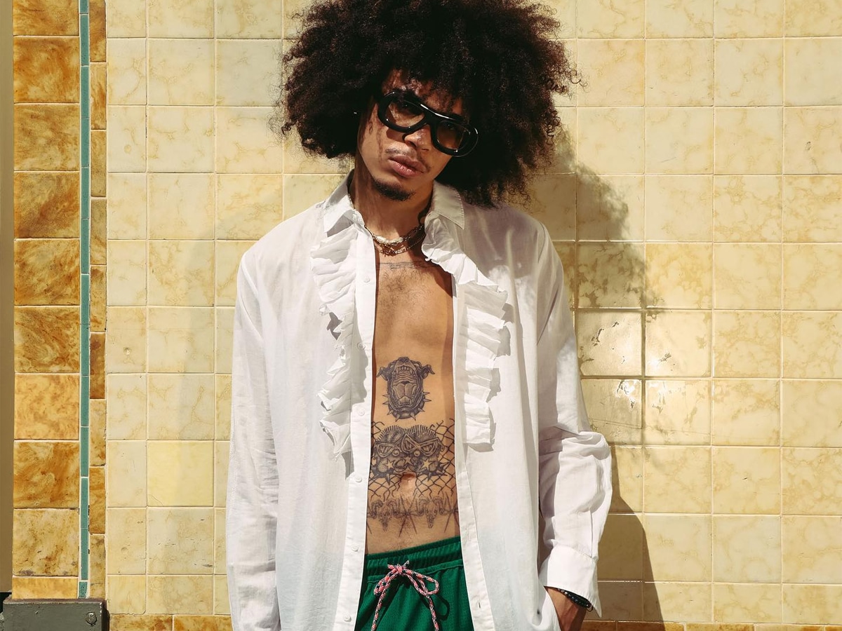 Male model in a white long sleeves shirt and green shorts