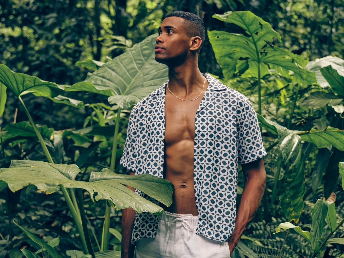 Male model in a blue pattern print shirt and white shorts
