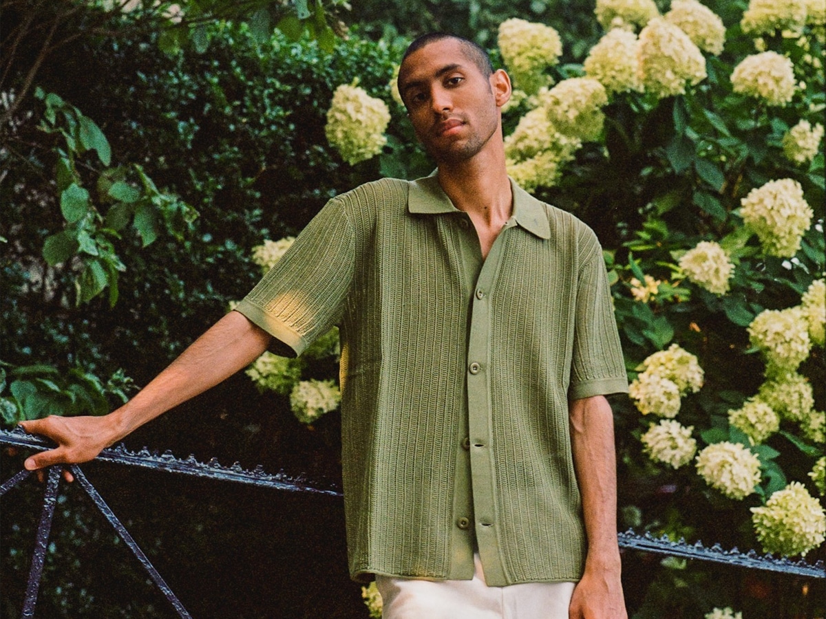 Male model in a green knitted shirt and white shorts