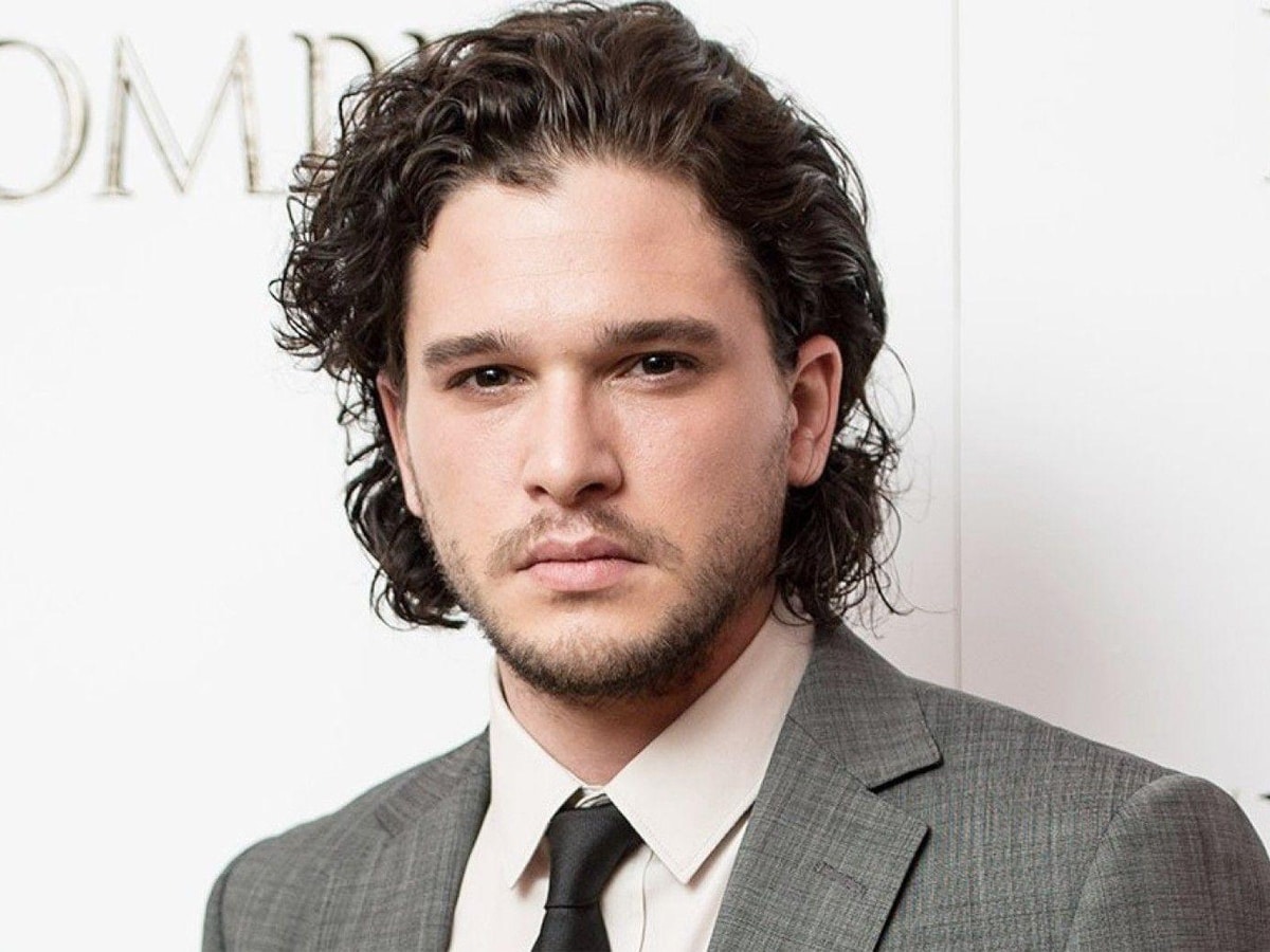 Kit Harington with a slicked-back curly quiff haistyle