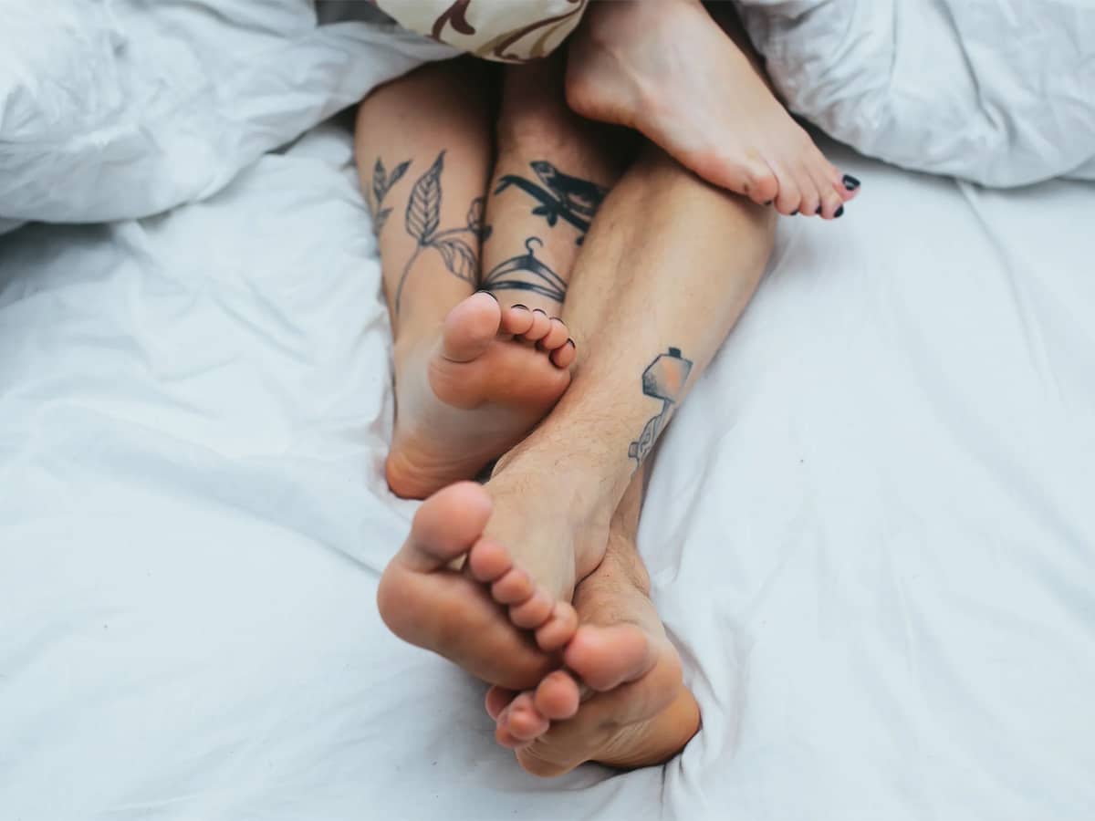 Couples' feet peeking out from the blanket