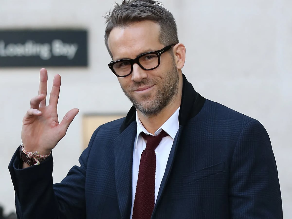 Ryan Reynolds in a suit and non-prescription glasses