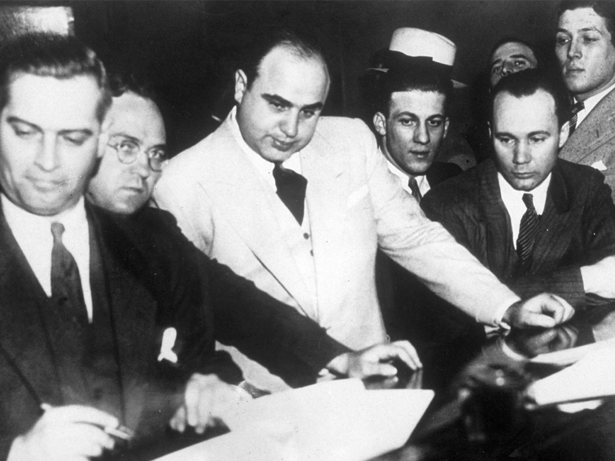 Greyscale image of Al Capone surrounded by other men