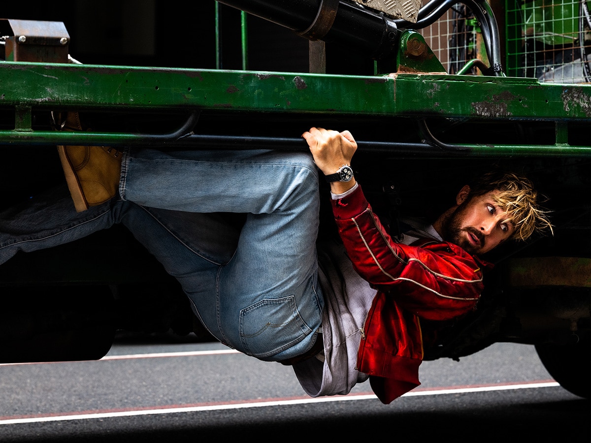 Ryan gosling climbing under a truck