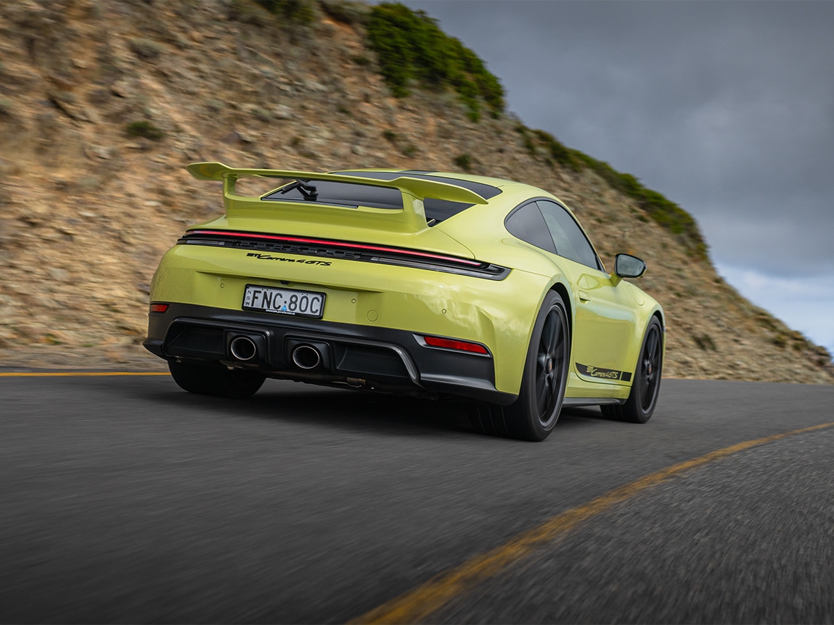 Porsche 911 carrera 4 gts rear three quarter driving on road