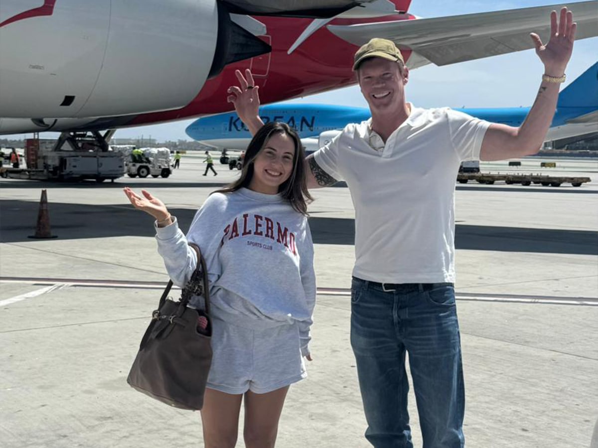 Justin fischer with his daughter in front of a qantas plane