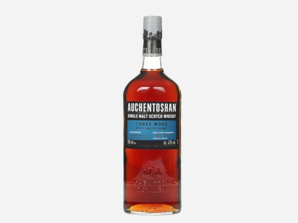 The Auchentoshan Three Wood Lowland Single Malt Scotch Whisky bottle showing the distinctive light-coloured liquid, which is triple-matured in American Bourbon, Oloroso Sherry, and Pedro Ximénez Sherry casks.