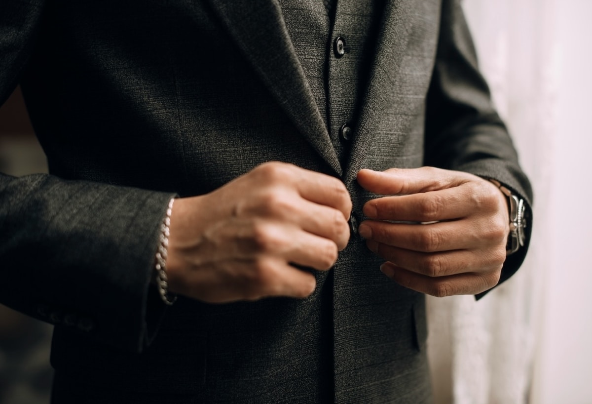 man buttoning suit jacket