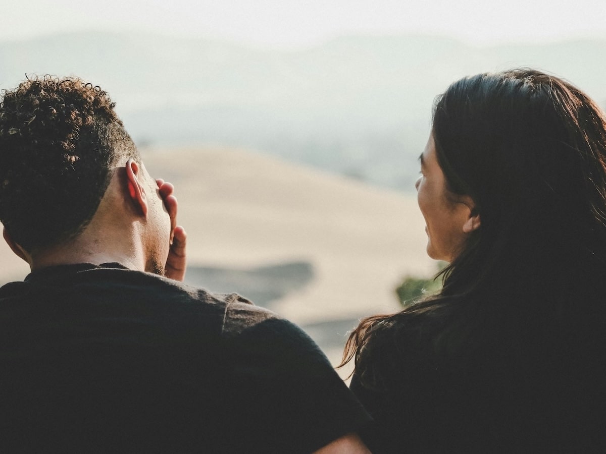 male and female couple talking looking out over scenic view
