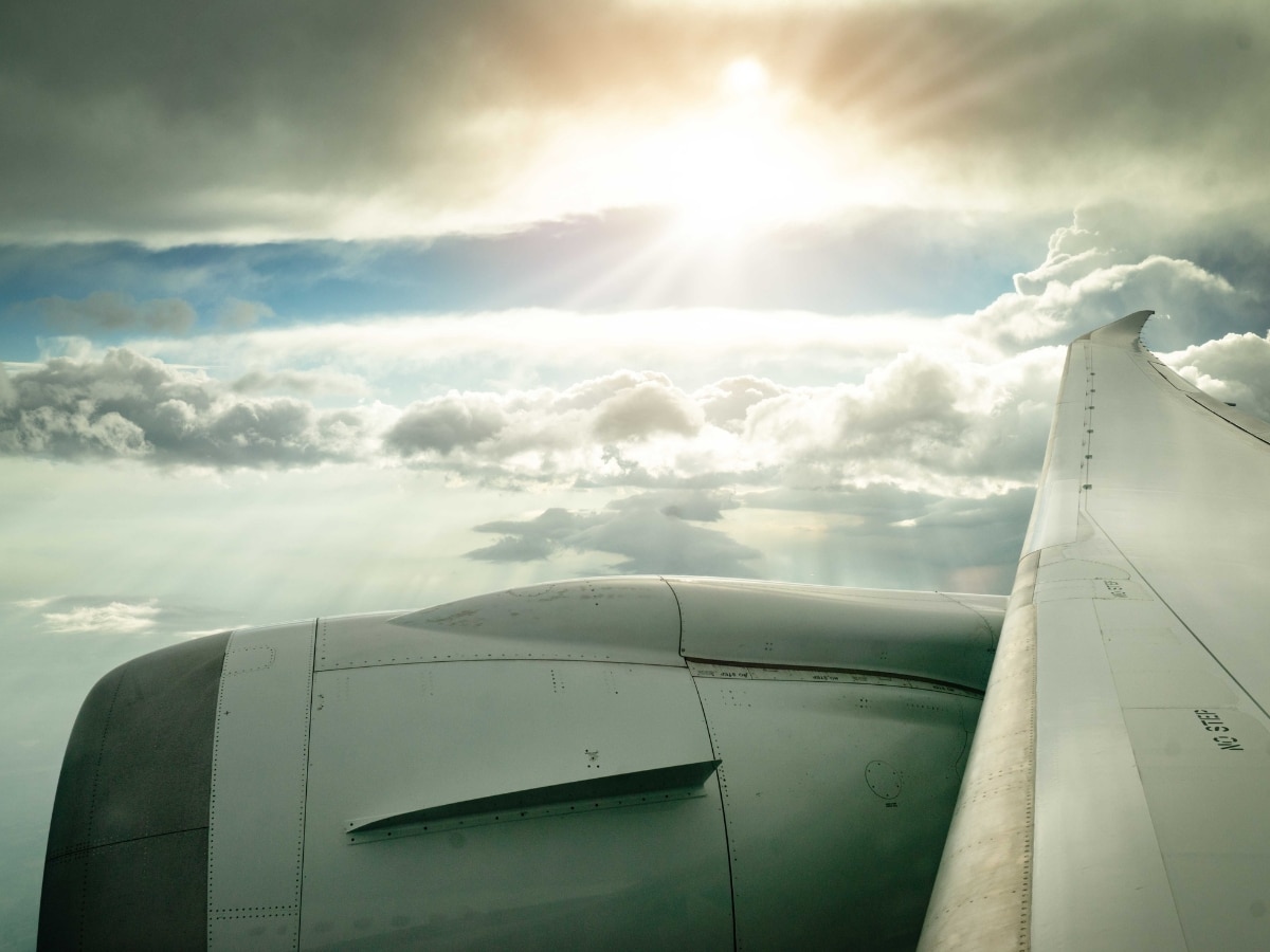 A view from the window of a plane flying over the clouds on a sunny day