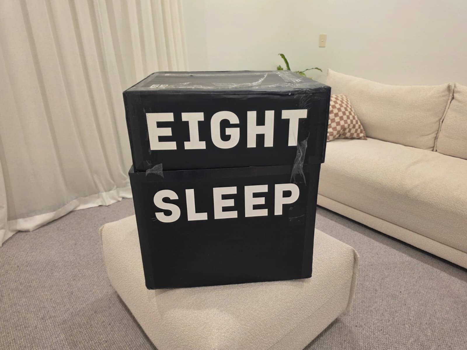 The Eight Sleep Pod 5 shipping box in a bedroom, still sealed