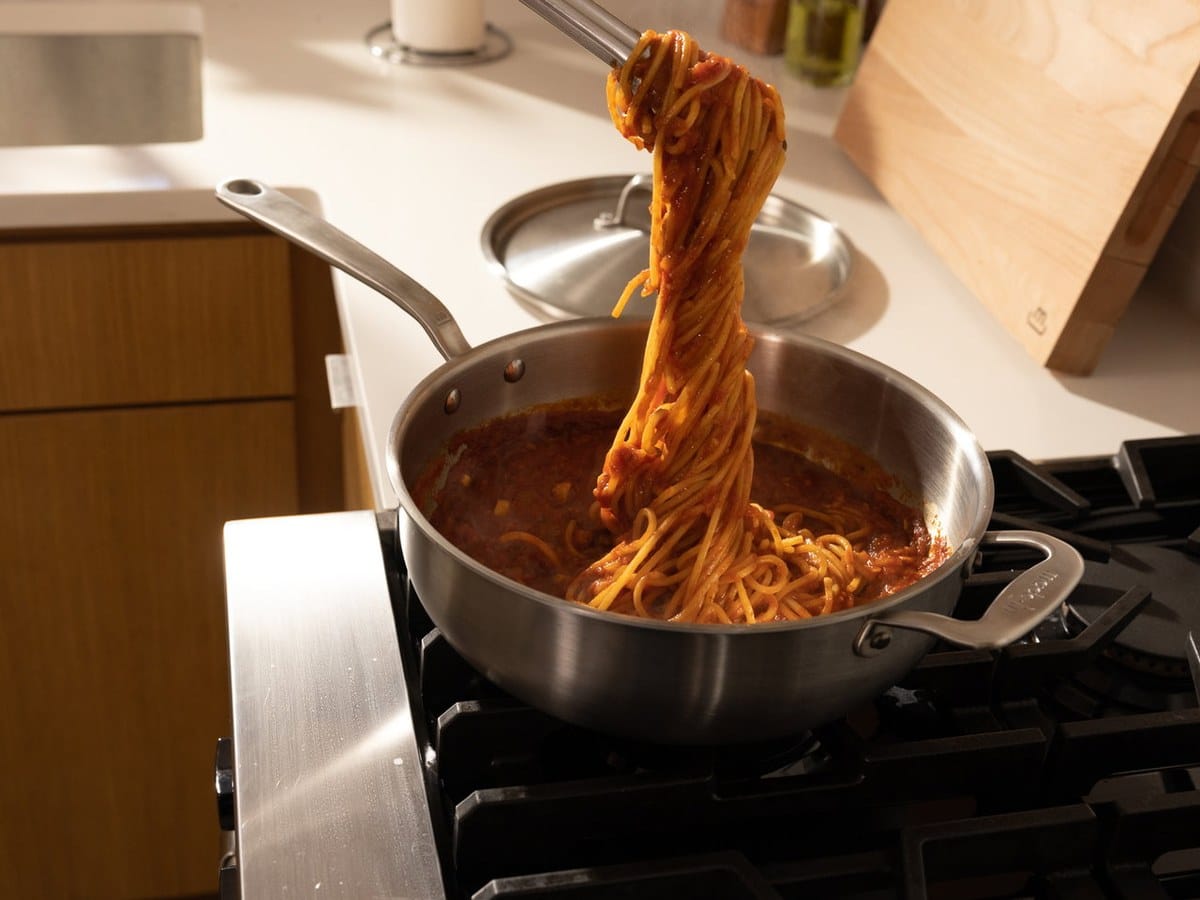 Pasta being tossed in a Made In Stainless Clad Sauté Pan