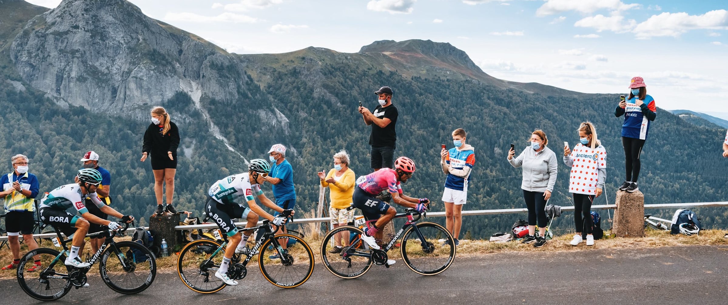 The Tour de France peloton climbs a mountain stage watched by fans
