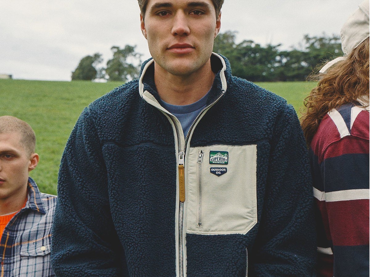 Man wearing the navy Superdry vintage retro full zip fleece with cream chest pocket panel