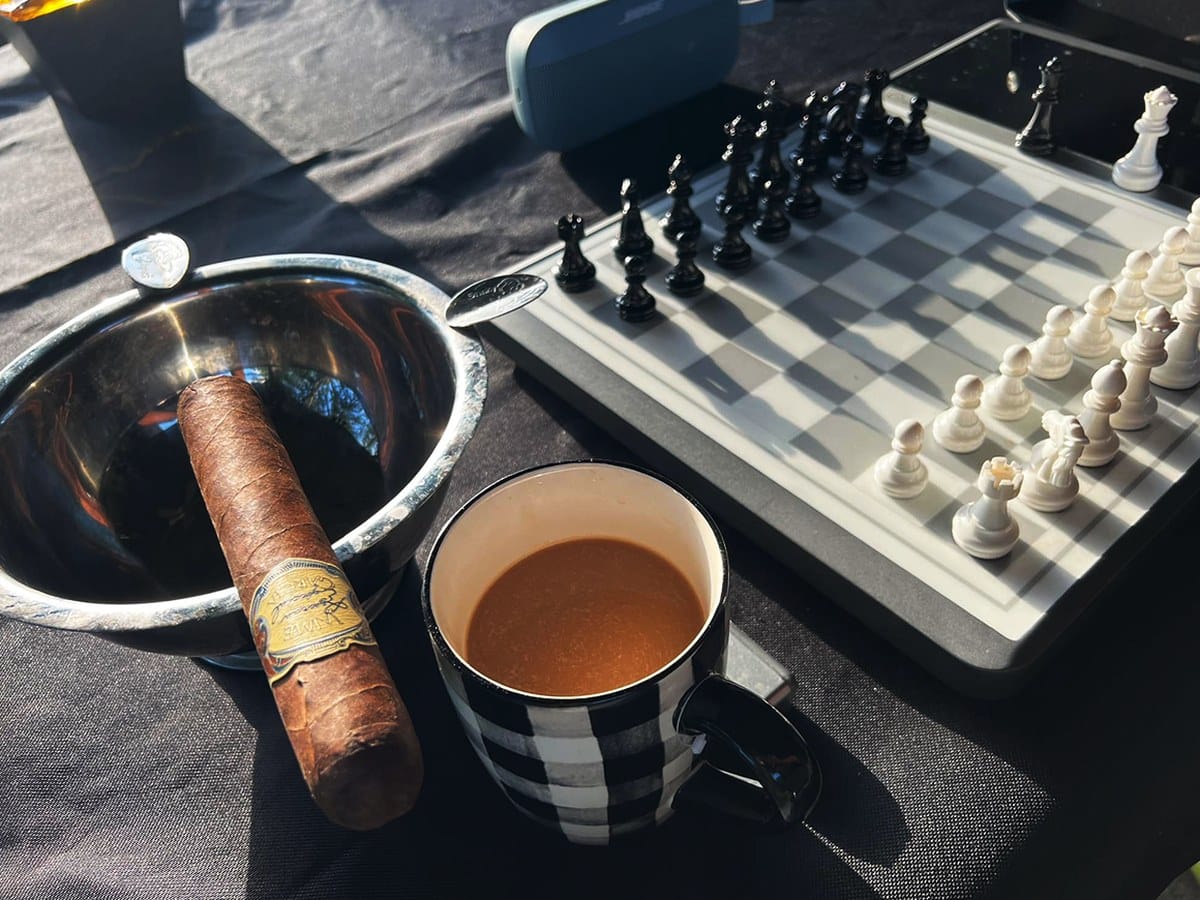 Chessnut Evo chess board on a table with coffee and a cigar