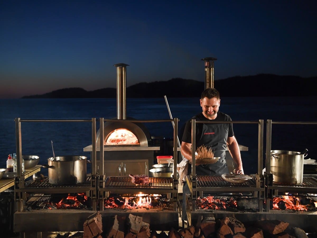 Lennox Hastie cooking over fire at a dinner at qualia on Hamilton Island