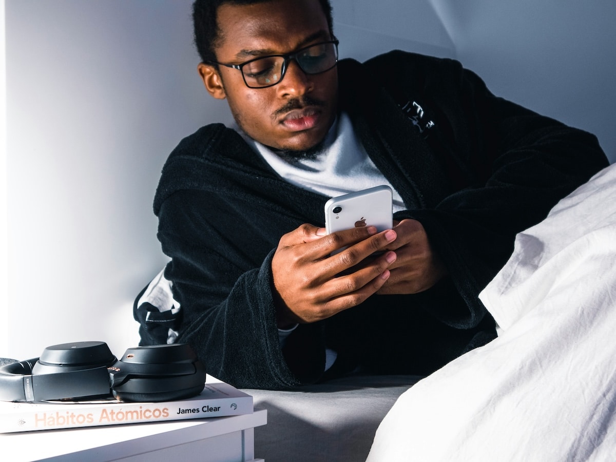 Man scrolling phone in bed