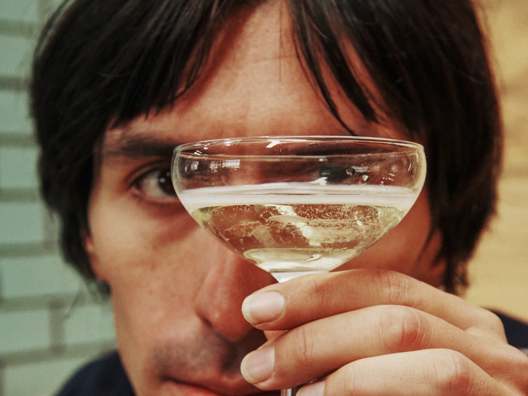 Close crop of a person's eye seen through a coupe glass of High Hopes sparkling wine